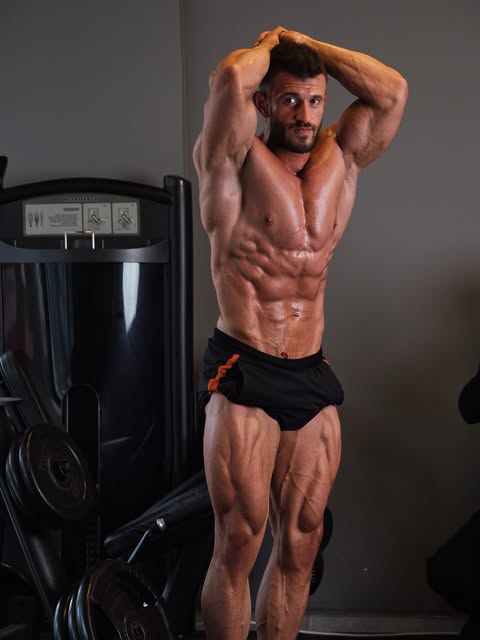Ömer Faruk Bayrak Overall Gym'de. Kollar başının üstünde.